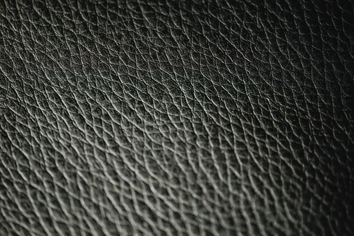 Close-up of dark pebbled leather surface texture — quality consistency across every unit in a production run is what AQL inspection is designed to verify before shipment is approved