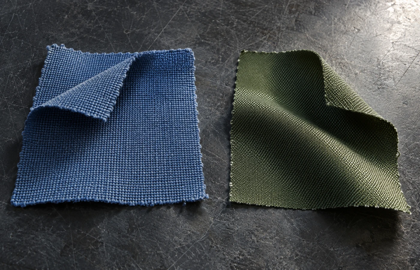 Illustrative close-up of blue and green woven fabric swatches with turned corners and curved folds
