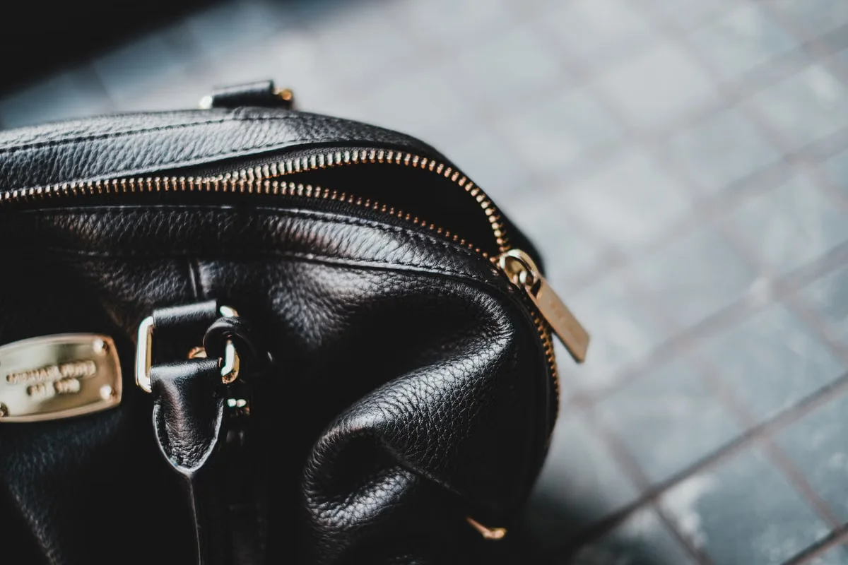 Close-up of black pebbled leather bag with gold zipper hardware — zipper gauge, pull type and hardware finish are dimension-adjacent specifications that directly affect how a crossbody bag functions in daily use