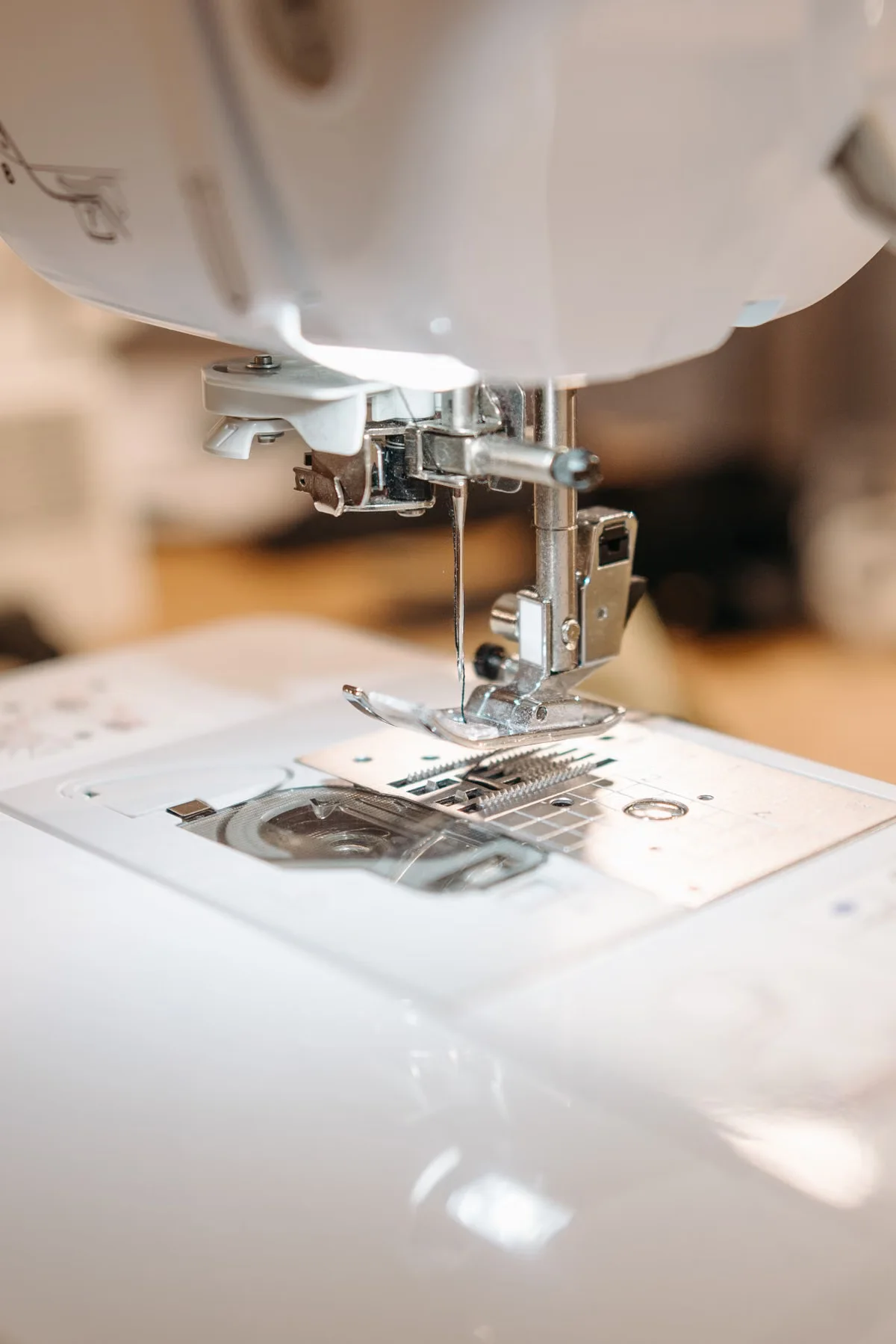 Close-up of an industrial sewing machine needle piercing through dark leather with precise thread tension — consistent stitch quality is one of the most reliable indicators of a leather goods factory's skill level
